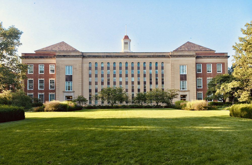 Brick university building behind a green lawn